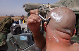 A Marine shaved his head during an operational pause in the push north to Baghdad